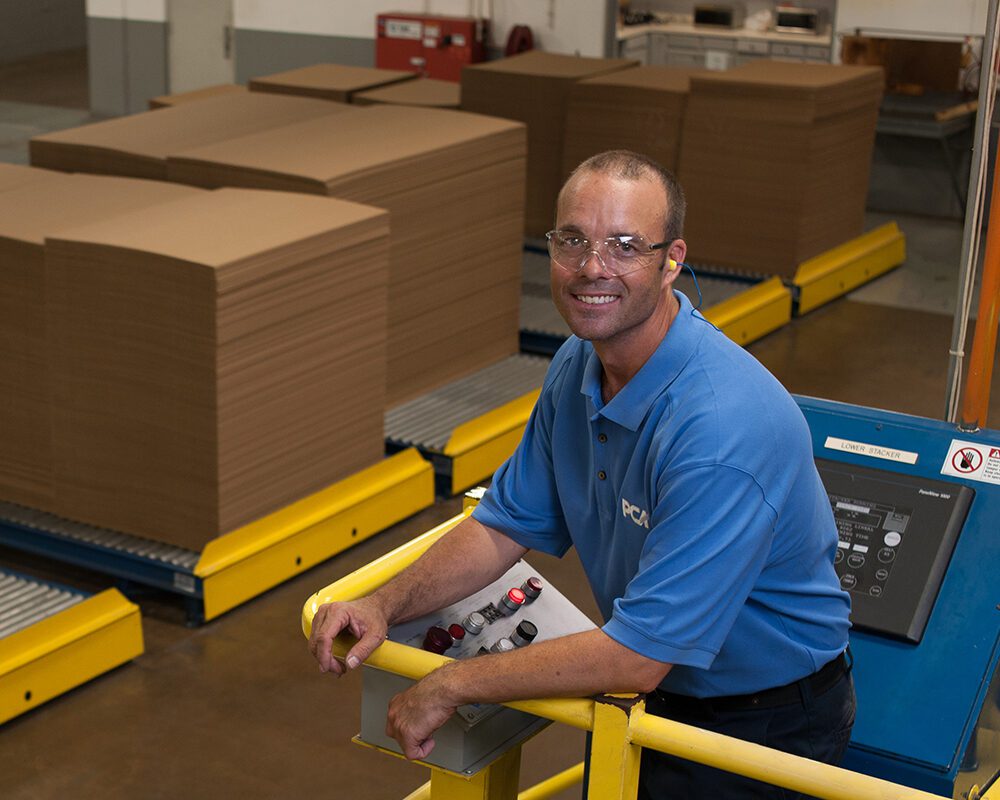 PCA Employee at Corrugator Control Panel