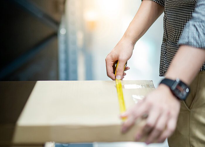 Man Measuring a Corrugated Package