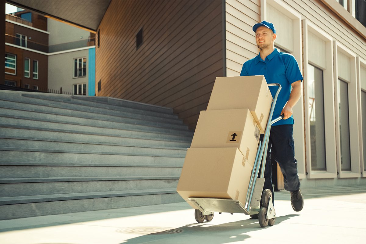 Man Moving Stack of Boxes on a Hand Truck