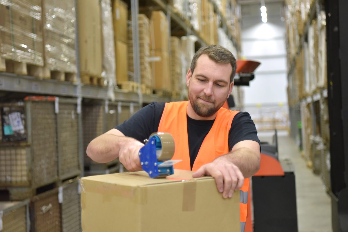 Man Taping a Box Closed