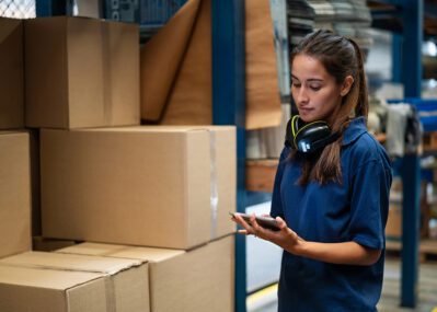 Woman Looking at Boxes in a Warehouse