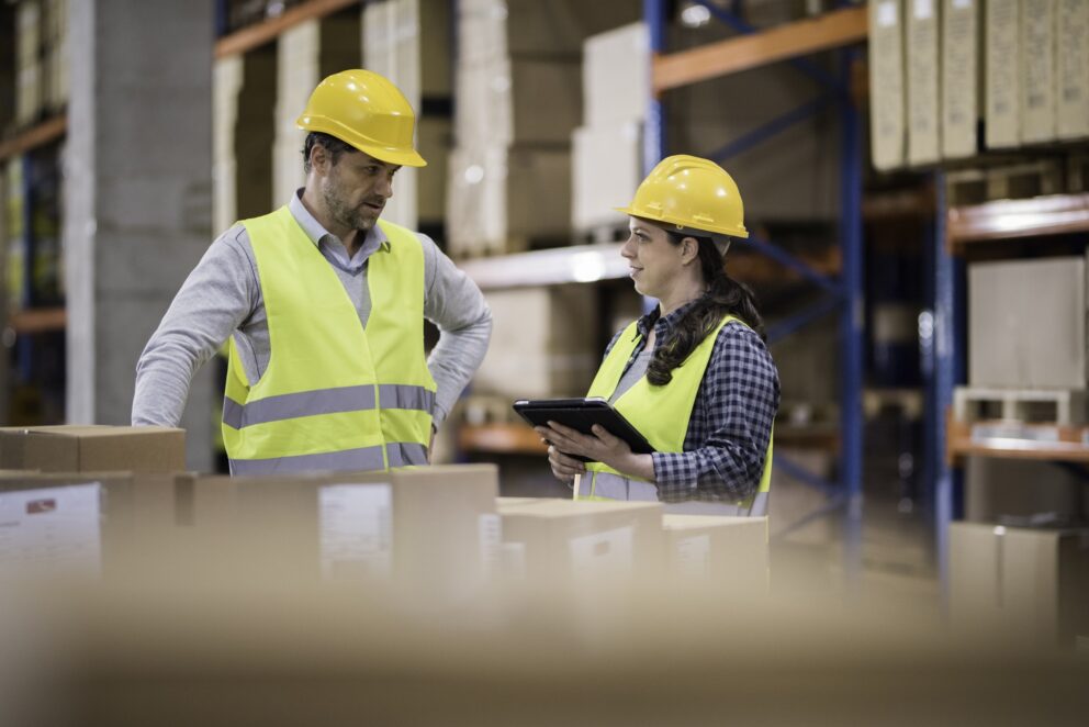 Two Workers in a Warehouse Filled with Boxes